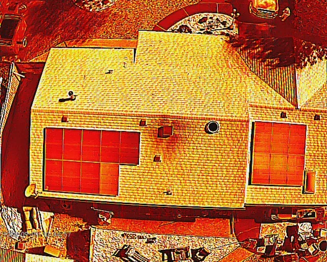 Color infrared drone image of a shingle roof and two solar arrays