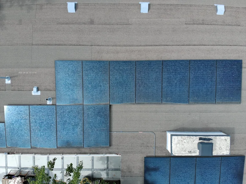 Overhead close-up of blue solar panels and rooftop vents
